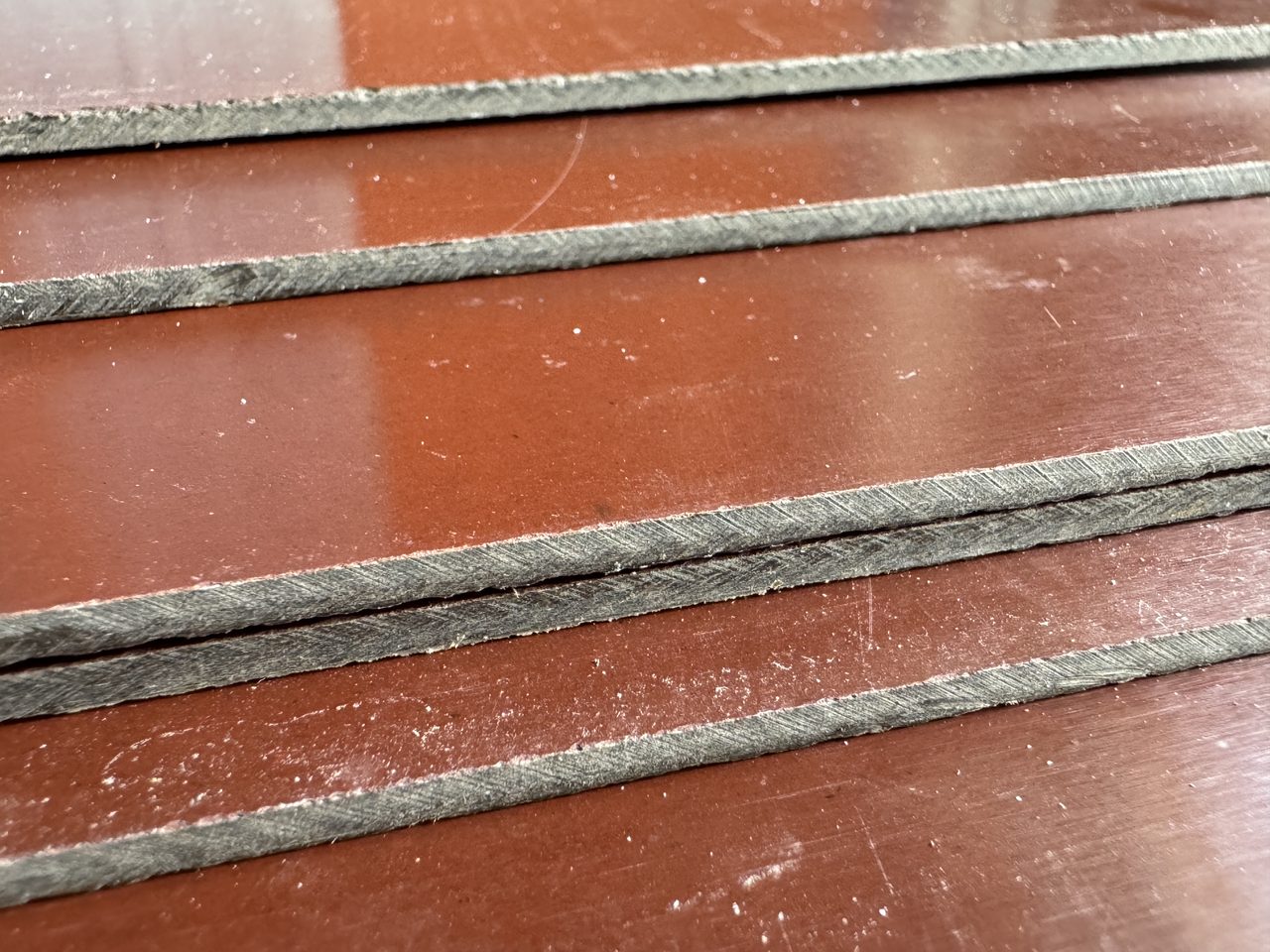 Mép cắt các tấm phíp nâu cốt giấy 3 mm xếp chồng, lõi màu xám có vân xiên