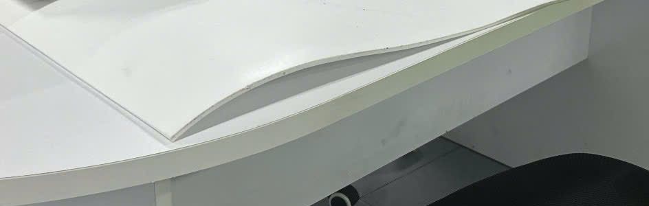 Chồng tấm nhựa PTFE mỏng trải trên bàn, mép tấm cong nhẹ