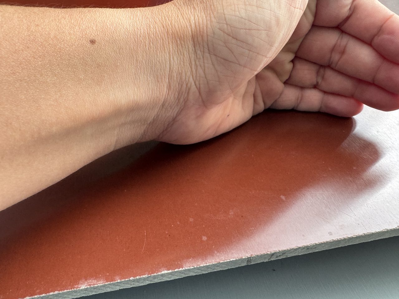 Tay đặt trên tấm phíp nâu cốt giấy 5 mm, mép tấm màu xám nhạt