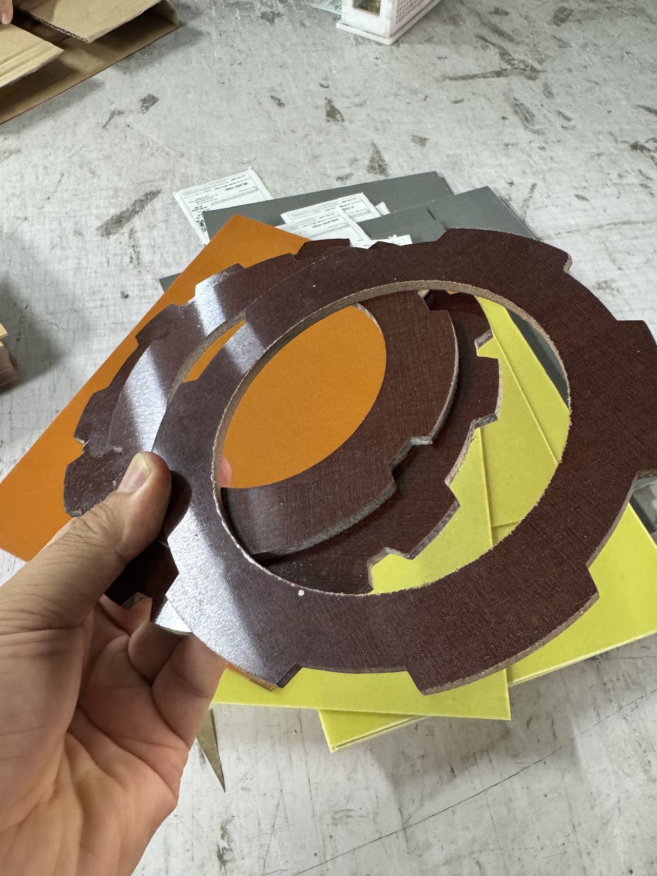 Hai vành răng phíp vải bố màu nâu cắt CNC cầm trên tay